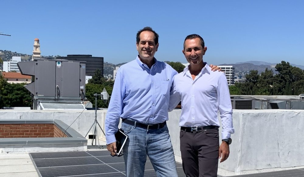 Mitchell Schwartz and Mark Samuel stand near solar panels on the roof of Temple Beth Am in Los Angeles.