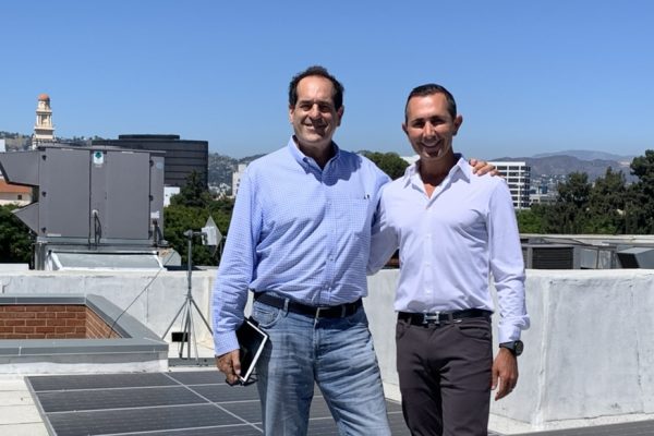 Mitchell Schwartz and Mark Samuel stand near solar panels on the roof of Temple Beth Am in Los Angeles.