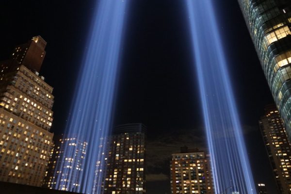 Article Banner - Twin blue lights mark the spot where the World Trade Center towers stood against a nighttime city background